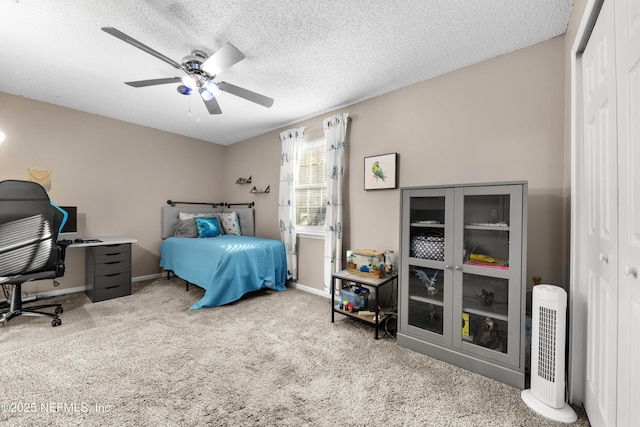 carpeted bedroom featuring ceiling fan, a closet, and a textured ceiling