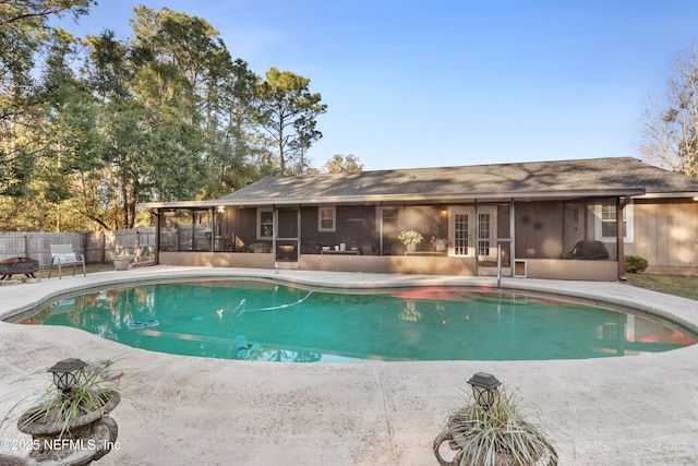 view of swimming pool featuring a patio area and a sunroom