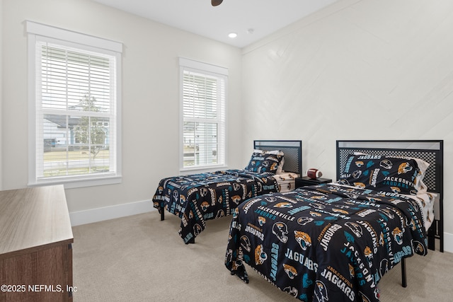 bedroom featuring light colored carpet and multiple windows