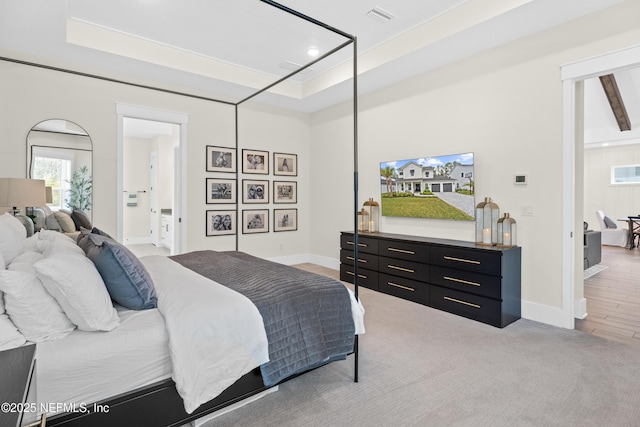 bedroom featuring a tray ceiling and light hardwood / wood-style floors