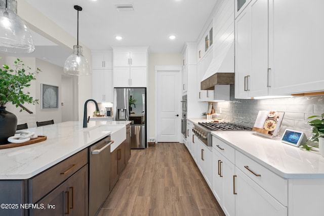 kitchen featuring white cabinets, decorative backsplash, and appliances with stainless steel finishes