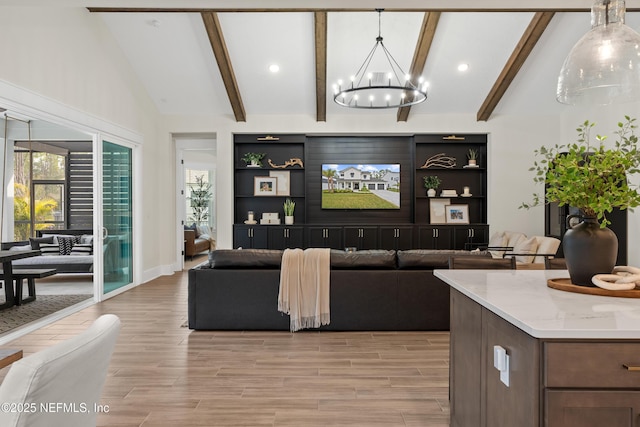 living room featuring built in shelves, lofted ceiling with beams, and a notable chandelier