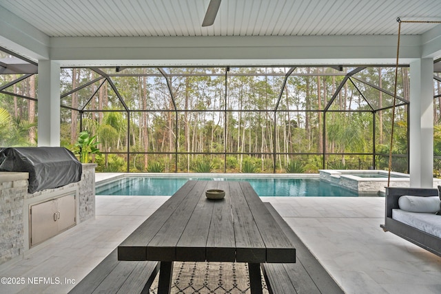 view of pool featuring an in ground hot tub, a lanai, an outdoor kitchen, and grilling area