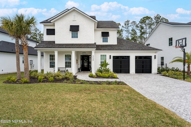 modern farmhouse featuring a front lawn, covered porch, and a garage