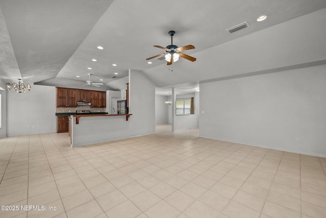 unfurnished living room with ceiling fan with notable chandelier and vaulted ceiling