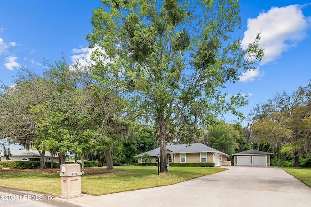 view of front of property featuring an outdoor structure, a front yard, and a garage