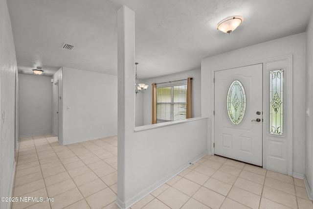 entryway featuring light tile patterned floors and a chandelier