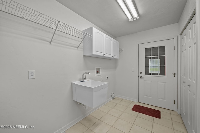 clothes washing area featuring cabinets, sink, washer hookup, light tile patterned floors, and hookup for an electric dryer