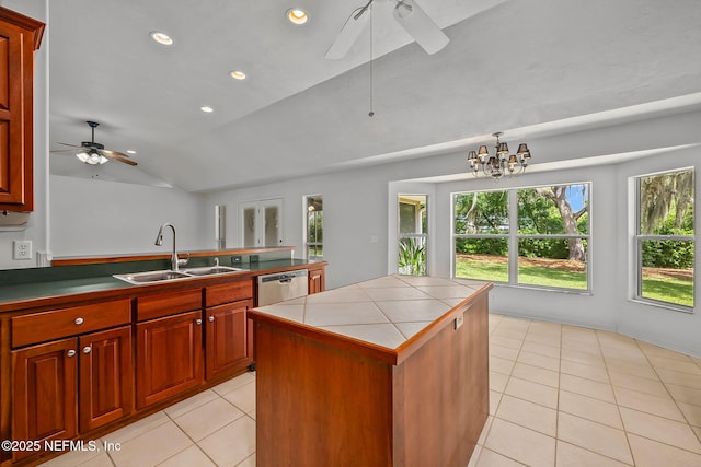 kitchen with stainless steel dishwasher, vaulted ceiling, sink, a center island, and tile counters