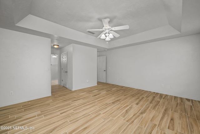 unfurnished room with a raised ceiling and ceiling fan