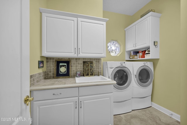 washroom featuring sink, washer and dryer, and cabinets