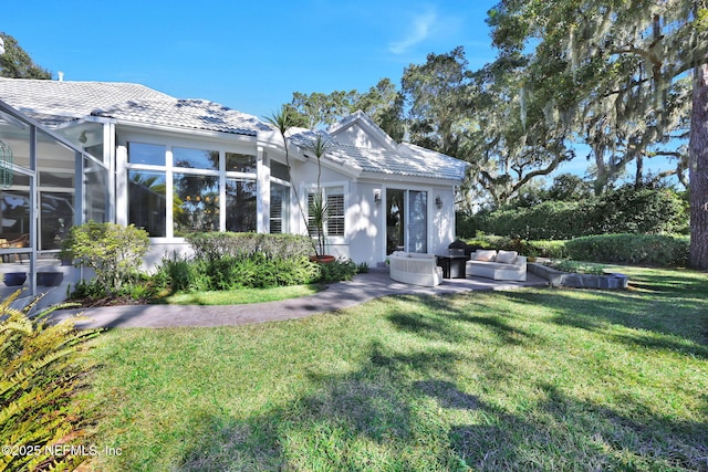 rear view of house with a yard and an outdoor living space