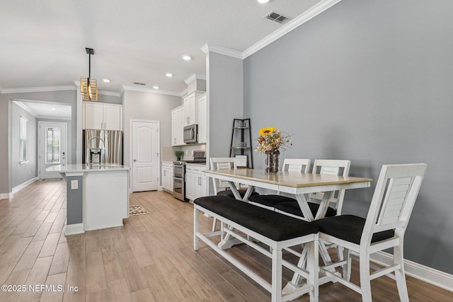 234 Thistleton Way, Saint Augustine, FL 32092 - kitchen with appliances with stainless steel finishes, a center island with sink, ornamental molding, recessed lighting, and light wood-style floors