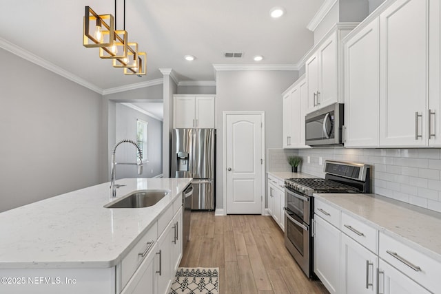 234 Thistleton Way, Saint Augustine, FL 32092 - kitchen with appliances with stainless steel finishes, white cabinetry, crown molding, a center island with sink, and tasteful backsplash
