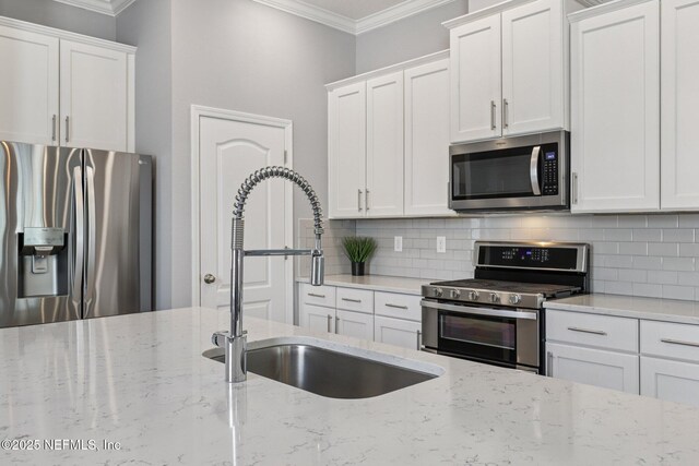234 Thistleton Way, Saint Augustine, FL 32092 - kitchen with stainless steel appliances, ornamental molding, white cabinetry, decorative backsplash, and light stone counters