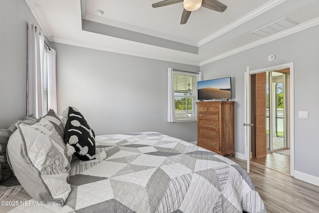234 Thistleton Way, Saint Augustine, FL 32092 - bedroom featuring wood finished floors, a tray ceiling, ornamental molding, and a ceiling fan