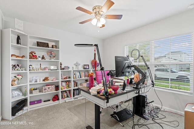 carpeted home office featuring ceiling fan