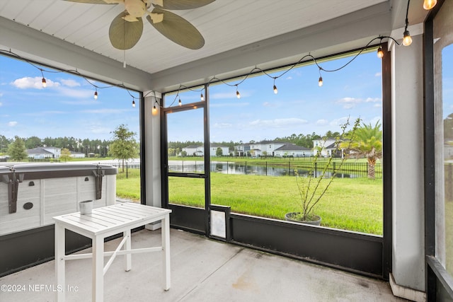 sunroom with a water view and ceiling fan