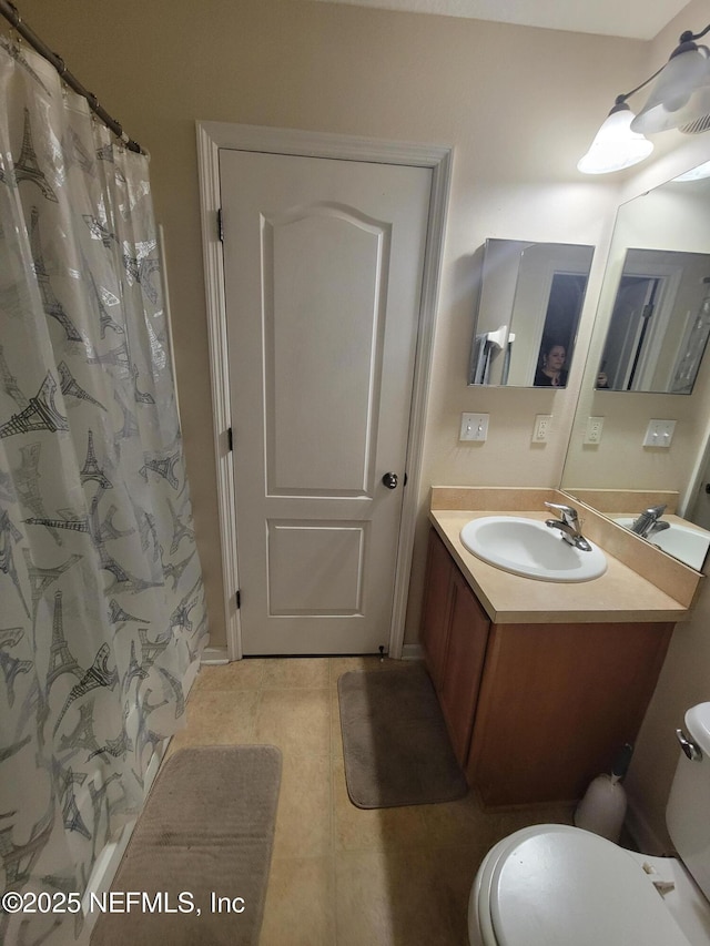 bathroom featuring a shower with curtain, tile patterned floors, vanity, and toilet