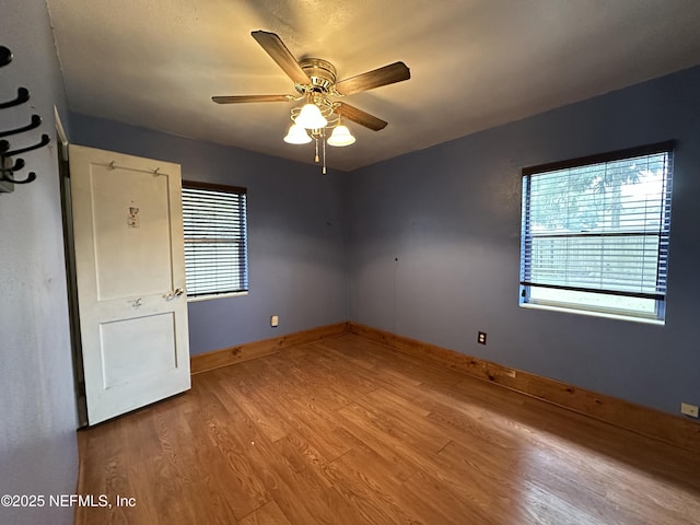 spare room with ceiling fan and wood-type flooring