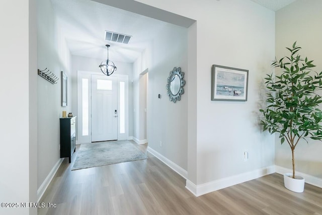 foyer featuring light hardwood / wood-style floors and a notable chandelier