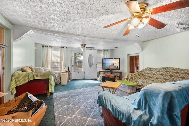 carpeted living room with ceiling fan and a textured ceiling