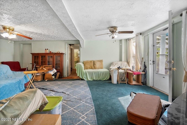 carpeted living room with ceiling fan and a textured ceiling