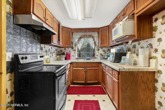 kitchen featuring sink, electric range, decorative backsplash, and light tile patterned flooring