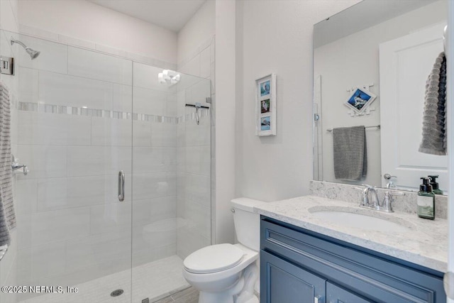 bathroom featuring toilet, an enclosed shower, and vanity