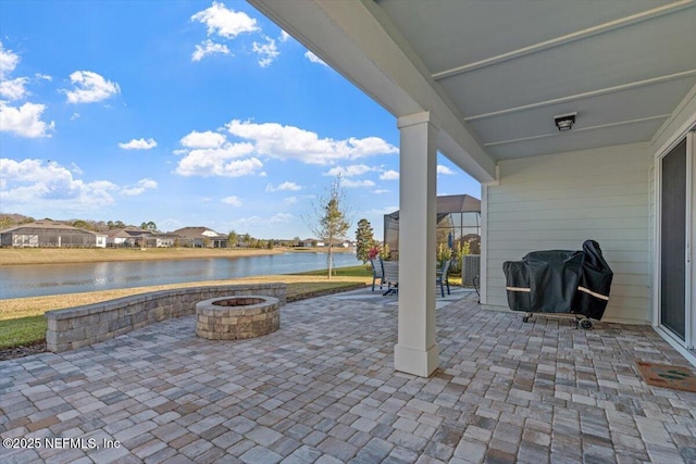 view of patio featuring an outdoor fire pit, a grill, and a water view