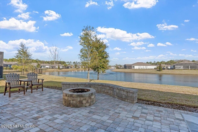 view of patio with a fire pit and a water view