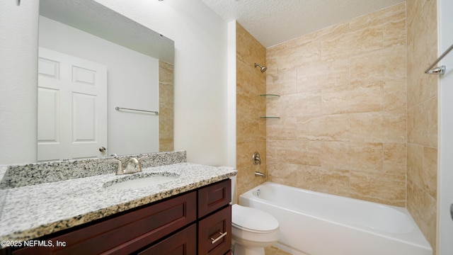 full bathroom featuring toilet, tiled shower / bath combo, vanity, and a textured ceiling