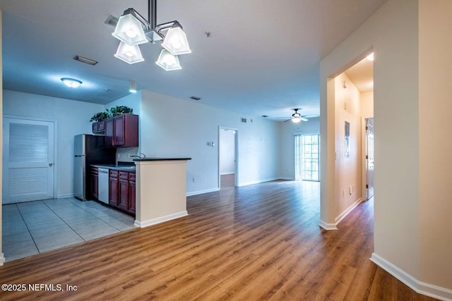 kitchen featuring ceiling fan, stainless steel appliances, light hardwood / wood-style flooring, and pendant lighting