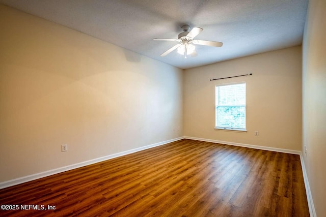 spare room featuring dark hardwood / wood-style flooring and ceiling fan