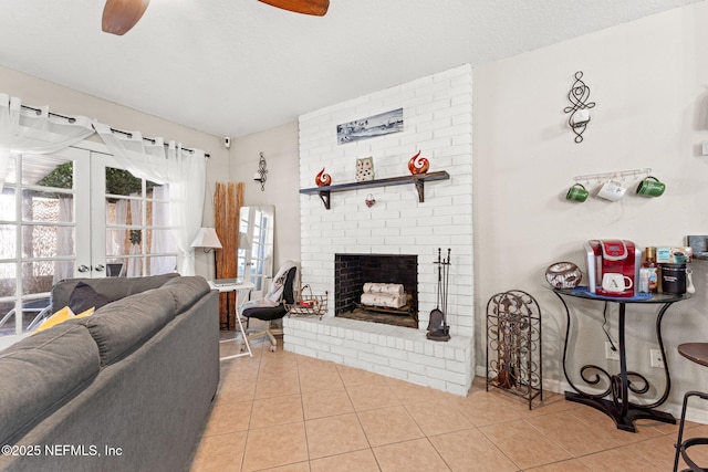 living room featuring light tile patterned floors, french doors, a brick fireplace, and a textured ceiling