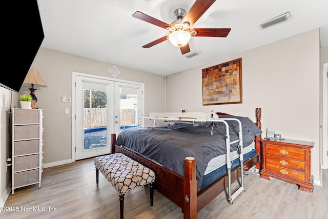 bedroom featuring a textured ceiling, french doors, light hardwood / wood-style floors, access to exterior, and ceiling fan