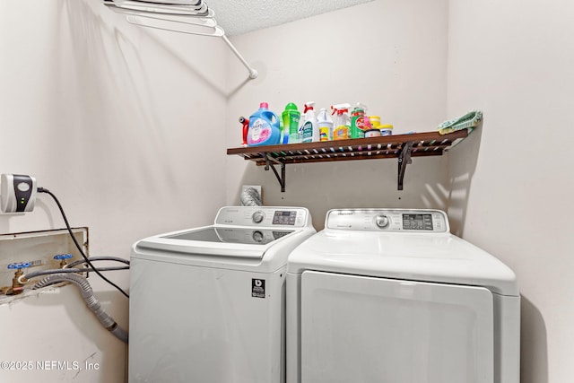 laundry room with a textured ceiling and washing machine and clothes dryer