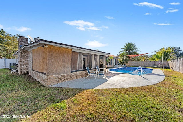 view of pool with a patio area, cooling unit, and a lawn