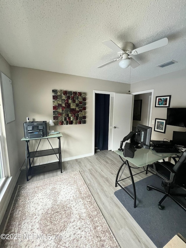 office area featuring ceiling fan, wood-type flooring, and a textured ceiling