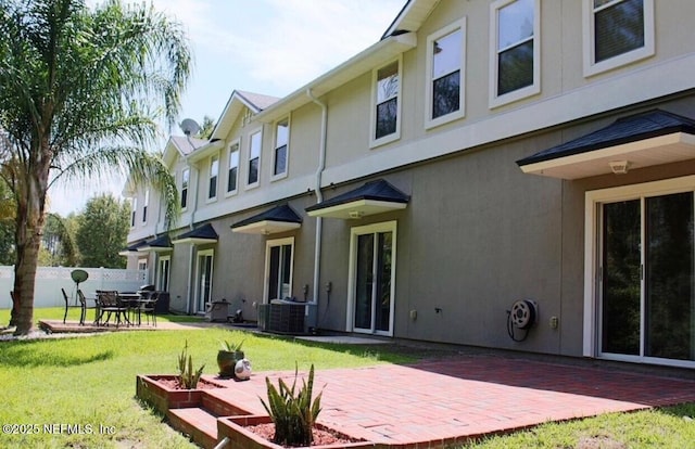 back of house with a patio, central air condition unit, and a lawn