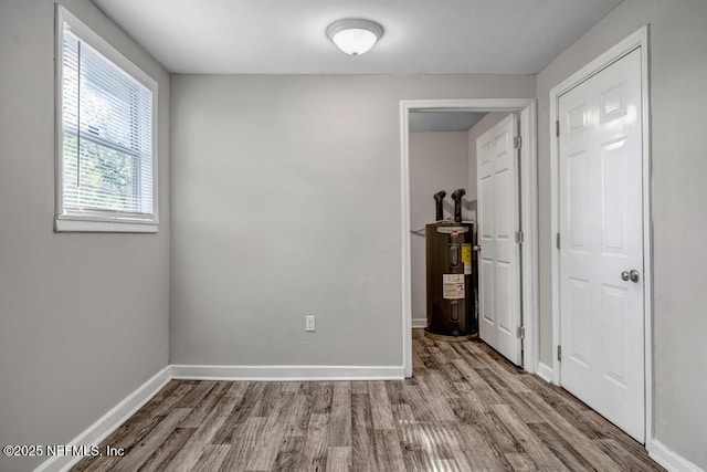 interior space with light hardwood / wood-style floors and water heater