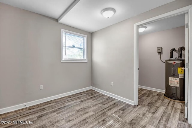 empty room featuring light hardwood / wood-style floors and electric water heater