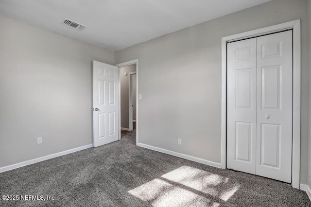 unfurnished bedroom featuring a closet and dark carpet