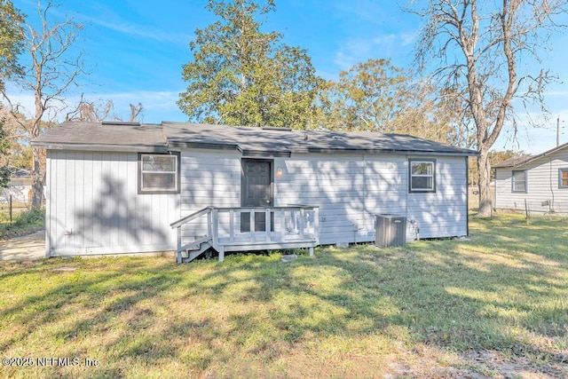 back of property featuring a lawn, central air condition unit, and a deck