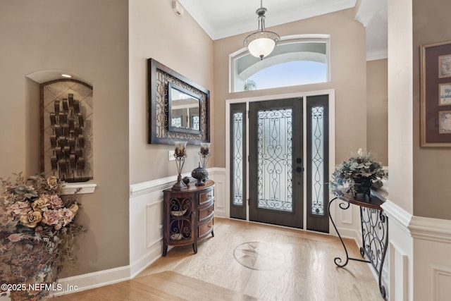 foyer entrance featuring ornamental molding and light wood-type flooring