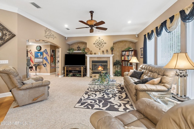 carpeted living room featuring crown molding and ceiling fan