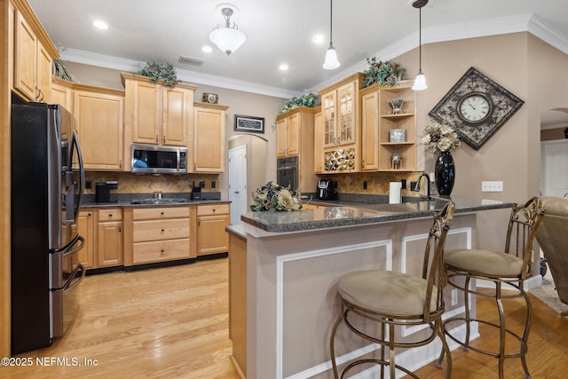 kitchen featuring pendant lighting, stainless steel appliances, kitchen peninsula, and a kitchen bar