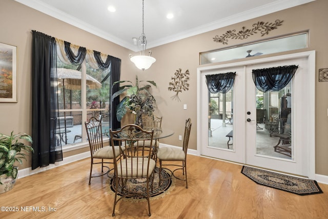 dining area with french doors, wood-type flooring, and crown molding