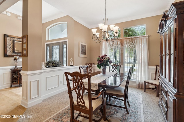 dining space featuring ornamental molding, plenty of natural light, light carpet, and a chandelier