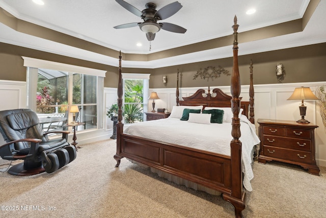 bedroom featuring crown molding, light colored carpet, and a raised ceiling